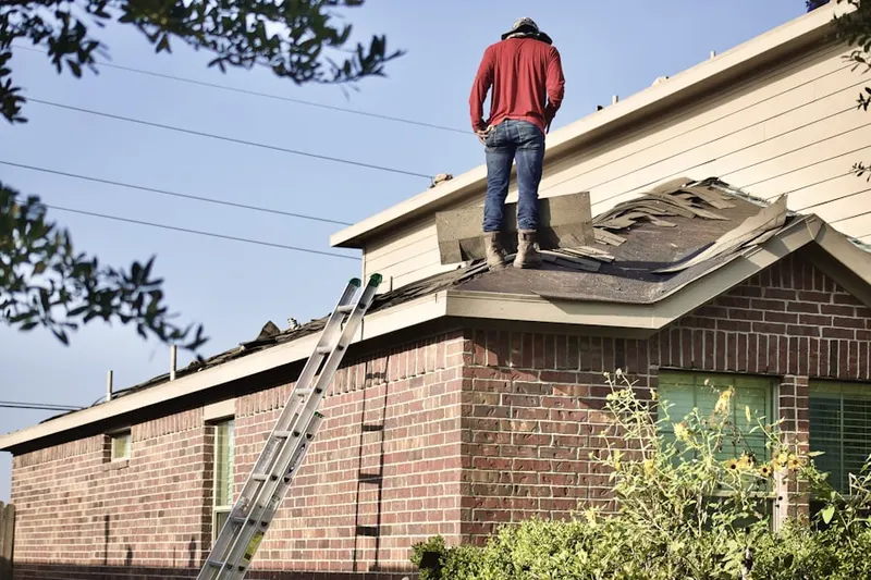 Professional roofer working on a residential roof in Bartles Corners